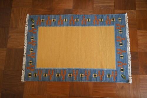RUGS: A yellow ground geometric rug, with blue border, 189 x 120cm