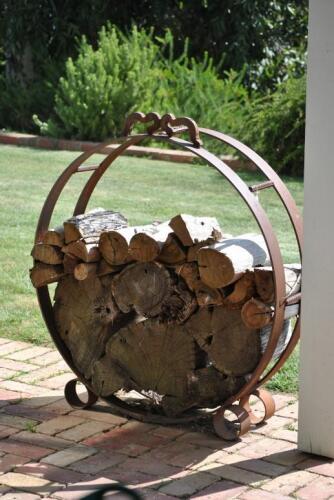 FIREWOOD RACK: A wrought iron circular firewood rack, 110cm high, 100cm wide *(see note)