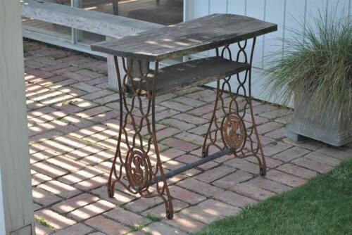 OUTSIDE TABLE: A Singer sewing machine cast iron base with later timber top, 75cm high, 88cm wide *(see note)
