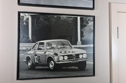 ALFA ROMEO: A framed period photograph of Bryan in his Alfa 105 competing in the Standard Production Class E with Tubby Ritter, signed and inscribed to verso &ldquo;The Bryan Thomson Collection&rdquo;