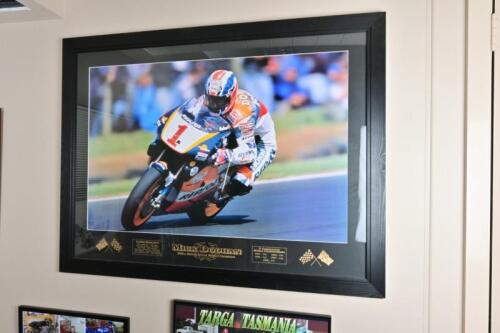 MICK DOOHAN: A large framed print celebrating Mick Doohan five consecutive 500cc motorcycle world championships, signed and inscribed to verso by Bryan Thomson