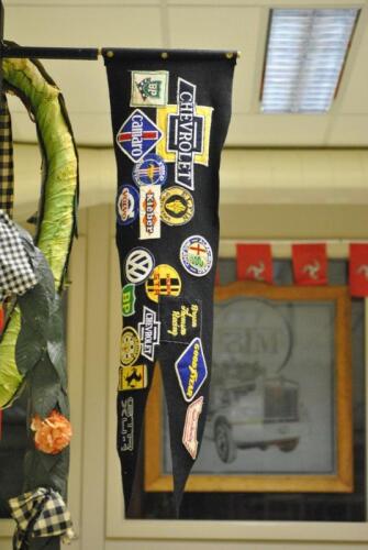 BRYAN THOMSON RACING: A felt flag with Bryan&rsquo;s personal badges and patchers applied which span his career in motorsport