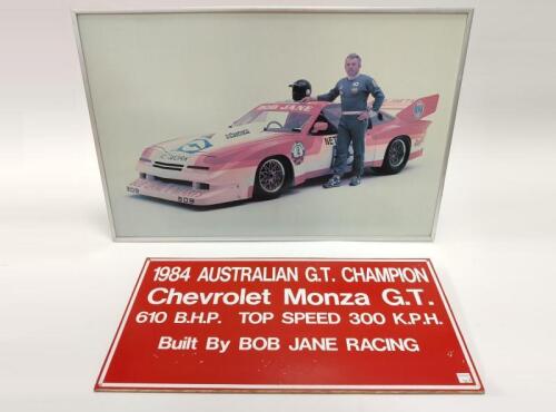 BOB JANE: A framed photograph of Bob Jane with his Monza GT together with a display board used in circa 1984, inscribed by Thomson