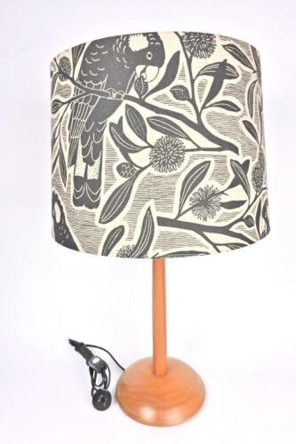 A black cockatoo decorated lampshade by Ann Mannion with base by Peter Sans, 27cm high, 34cm diameter