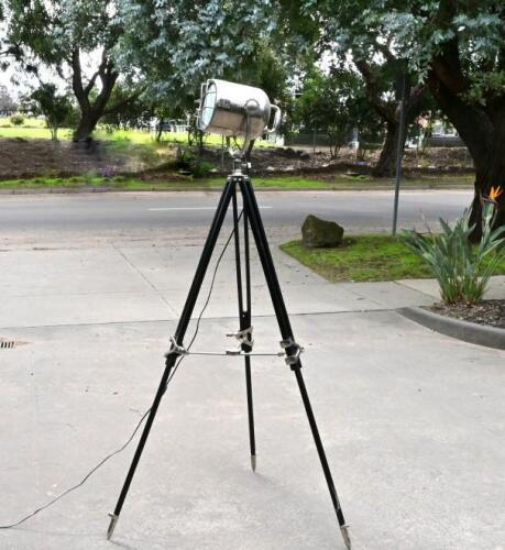 STUDIO SPOTLIGHT: A reproduction aluminium studio spotlight on black painted tripod stand, 174cm high