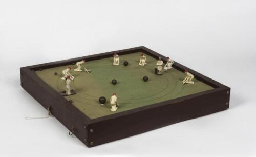 CRICKET GAMES: A vintage tabletop cricket game, with felt playing surface, deployable lead fielders and steel ball bearings, the bowler and batsman both spring loaded, 7cm high, 48.5cm wide, 48.5cm deep