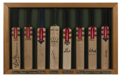 SIGNED MINIATURE CRICKET BATS: A collection of eight signed miniature cricket bats in a box frame , with signatures from Brian Lara, Allan Border, Sunil Gavaskar, Ian Botham, Donald Bradman, Viv Richards, Steve Waugh, Ian Chappell and Sachin Tendulkar, th