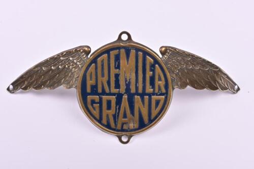 BADGE: An early 'Premier Grand' pressed brass convex winged badge