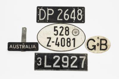 NUMBER PLATES: A collection of number plates from various countries including Germany, United Kingdom. 'AUSTRALIA' placard plate