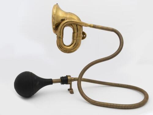 HORN: A brass horn with reticulated hose. 165cm long x 25cm wide