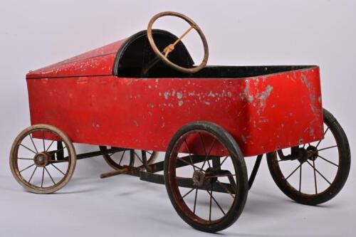 PEDAL CAR: A postwar childrens red metal pedal car, 49cm high x 91cm wide