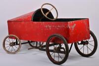 PEDAL CAR: A postwar childrens red metal pedal car, 49cm high x 91cm wide