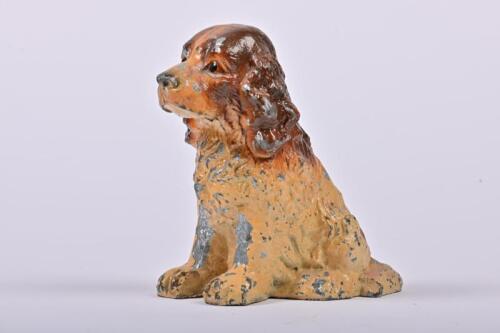 MONEY BOX: A white metal seated spaniel form money box by Iron KLT, English first half of the 20th century