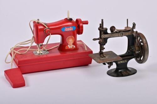 SINGER: A child's cast iron Singer sewing machine, first half of the 20th century, 18cm high, together with another child's Annie themed 1980s sewing machine, 17cm high