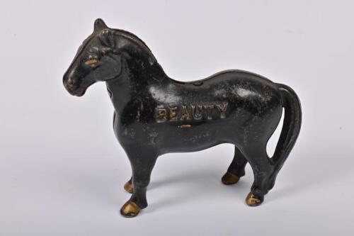 MONEY BOX: An American black painted cast iron 'Beauty' money box by Arcade between 1910-1932, 11cm high