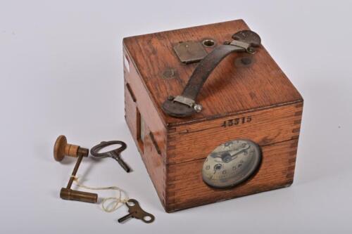 PIGEON CLOCK: A circa 1930 Plasschaert Frs. pigeon racing clock, circa 1930, in oak box with a clock face marked Plasschaert Frs, Wachtebeke, Belgique, box impressed 43315, with two keys, not recently serviced or timed, 14cm high, 16cm wide, 18.5cm deep