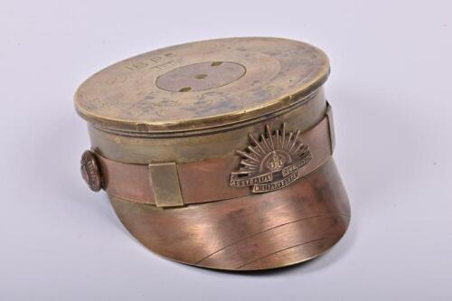 TRENCH ART: A WWI Trench art cap made from a 1917 brass artillery shell with Australian military badge and buttons, 10cm diameter