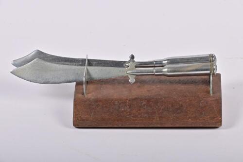 TRENCH ART: A 1944 desk ornament in the form of two mounted dadoa swords made from bullets, inscribed New Guinea 1944, 19cm wide