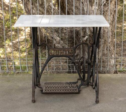 TABLE: An antique cast iron table with marble top, 74cm high x 81cm wide