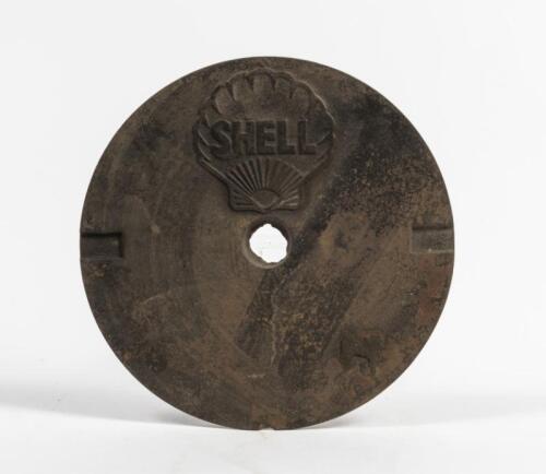 SHELL: A cast iron service station underground tank filler cover plate with SHELL lettering inside Shell Clam, 27cm diameter. Good Original condition.