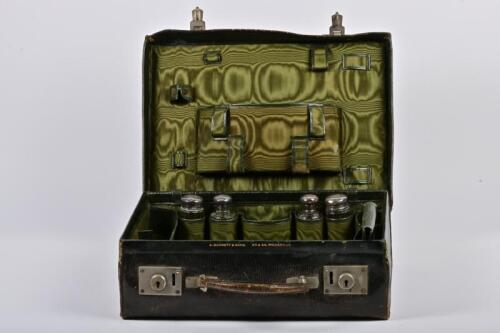 VANITY CASE: An Edwardian leather travelling vanity case with six sterling silver lidded jars hallmarks for London, 1904, Andrew Barrett & Sons, a burner and another container, 30cm high, 41cm wide, 13cm deep