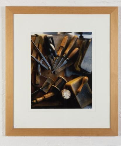 LEATHER TOOLING: A decorative photograph of leather and wood tools, mounted, framed and glazed, 85cm x 74cm