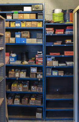 AUTO ELECTRONICS: A collection of parts in two metal shelves left by an automotive electrician that worked on the site, including lamps fuses etc