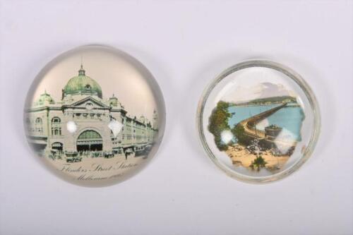 PAPERWEIGHTS: Two transport themed glass paperweights, one depicts Flinders Street Station, the other depicts the Victor Harbor Horse Tram Line, , the largest 8cm diameter