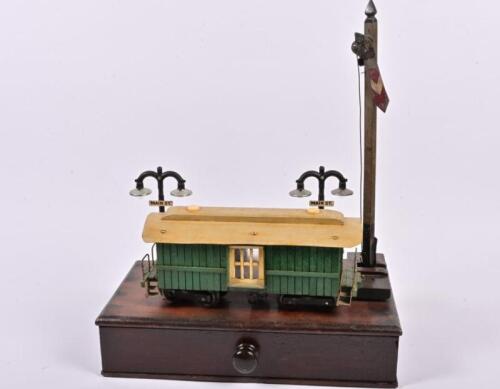 A vintage scratch built wooden model railway carriage on cedar stand with single drawer, with two sets of streetlights and and signal, 55cm high, 47cm wide, 25cm deep