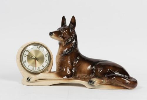 JEMA CLOCK: A 1960s Dutch German ceramic shepherd dog form clock, manufacture in West Germany, impressed to base: Jema HOLLAND, 27cm high, 44cm wide, 14cm deep