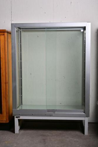DISPLAY CABINET: A late 20th century aluminium display cabinet, with two glass sliding doors, 109cm high, 76cm wide, 35cm deep
