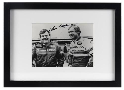 PORSCHE: A period photograph of Alan Jones and Vern Schuppan in 1984, signed by Vern in black marker