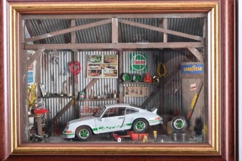 PORSCHE: A well detailed 1:43 scale diorama featuring a 1973 Porsche 911 RS 2.7 in a rustic workshop.