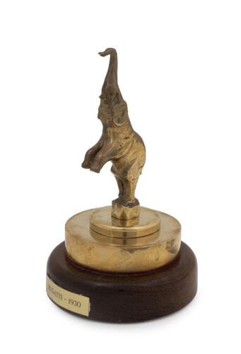 BUGATTI: A reproduction of a 1930s Bugatti rearing elephant form brass car mascot hood ornament on wooden base, 18cm high
