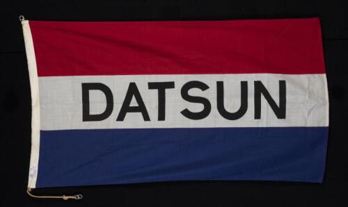 DATSUN: A fabric Datsun flag, made by "Evan Evans Flags" Melbourne, two MOSS sister clips on both sides, with original rope, 87cm high x 153cm wide
