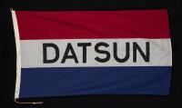 DATSUN: A fabric Datsun flag, made by "Evan Evans Flags" Melbourne, two MOSS sister clips on both sides, with original rope, 87cm high x 153cm wide