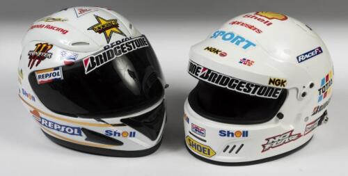 HELMETS: A two white racing helmets with applied racing stickers in large sized