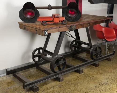 HALL TABLE: A decorative railway platform trolley adapted to table on track base, with 'MB' cast metal logo to the support rail, 102cm high, 242cm wide, 81cm deep