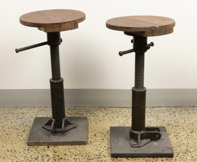 STOOLS: A pair of industrial style cast metal and timber stools