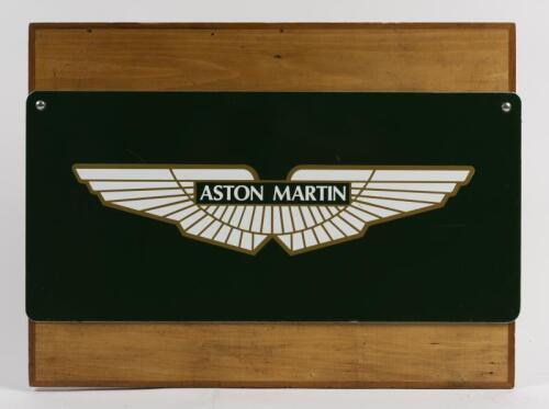 ASTON MARTIN: An Aston Martin sticker laid down on aluminium sheet and screw to wooden board, 46 x 61cm
