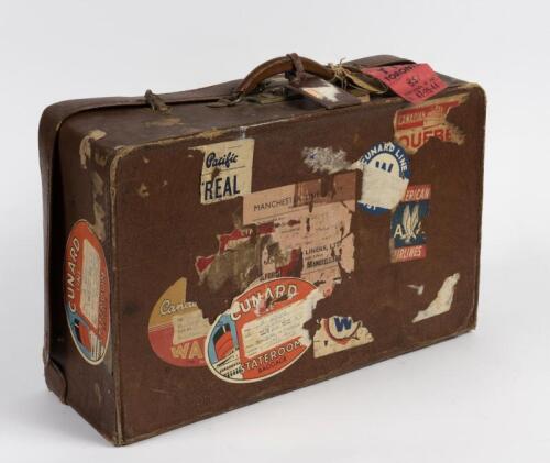 SUITCASE: A vintage leatherette suitcase with numerous travel stickers and tags including QE II and American Airlines, 34cm high, 34cm wide, 18cm deep