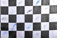 CHEQUERED FINISH LINE FLAG: An exceptional Formula One chequered finish line flag with COA, autographed by Michael Schumacher, Mark Webber, David Coulthard and 27 F1 personalities (30 signatures in total) 1520x900mm - 3