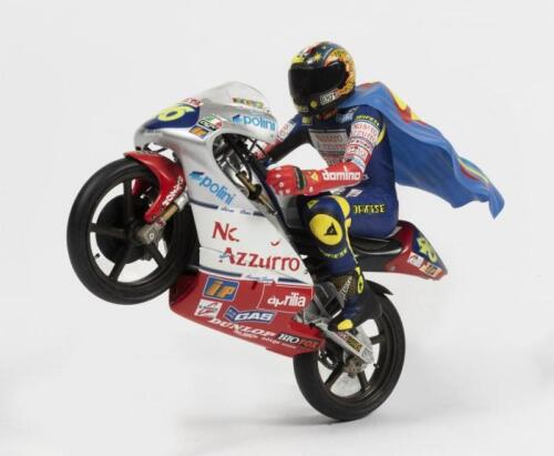 ROSSI: A 1:18 scale Valentino Rossi aprilia by Minichamps in 'Nastro Azzurro' livery. Valentino Rossi figurine including 'SUPERFUMI' blue cape
