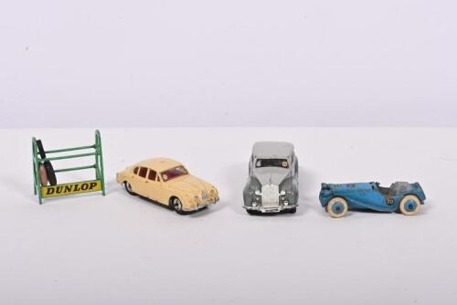 DINKY: A collection of four Dinky Toys. Rolls-Royce Silver Wraith, Jaguar 3.4 Litre, Jaguar SS100 models. With 'DUNLOP' tyre rack