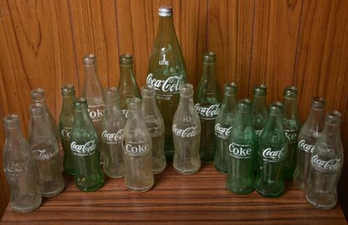 COKE: A collection of old Coke bottles of various periods and size