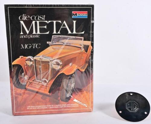 M.G: Two M.G related items including a Monogram die-cast METAL and plastic MG-TC 1:24 scale kit, kit sealed in factory plastic, with 'MG' silver plated steering wheel badge