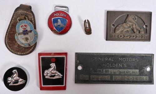 G.M.H: A group of car badges and keyrings including "THE LION" plastic and brass emblems, a Chevrolet (G.M.H) Stack and Company key ring; together with General Motors Holden's engine plaque