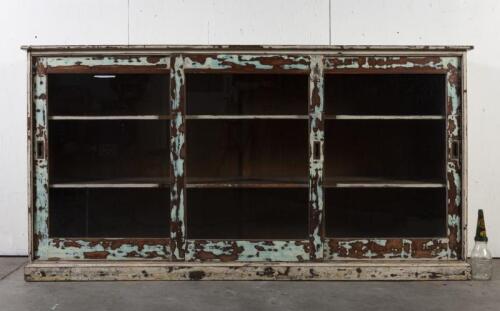 DISPLAY CASE: A large three sliding door display case with distressed finish, first half of the 20th century, 121.5cm high, 234cm wide, 54cm deep