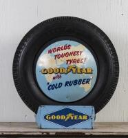GOODYEAR: A circa 1960s Goodyear tyre with printed and embossed plastic sign on tin tyre stand, the tyre stand printed to lower right hand side: Standard Industries Pty Ltd Sydney 2.67, 74cm high overall