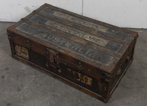 TRAVEL TRUNK: An early 20th century iron and wood bound travel trunk, 32cm high, 92cm wide, 53cm deep